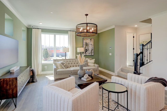 living room with ornamental molding, a chandelier, and light hardwood / wood-style floors