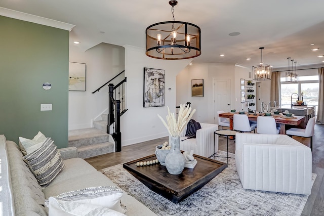 living room with hardwood / wood-style flooring, ornamental molding, and a notable chandelier