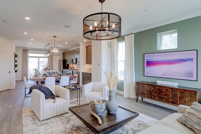 living room featuring light hardwood / wood-style floors and a notable chandelier