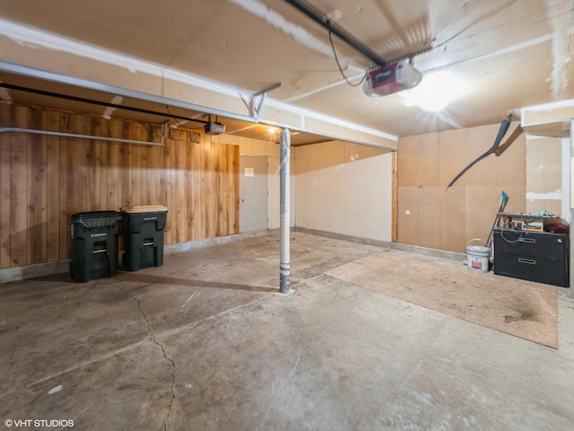 garage with a garage door opener and wood walls