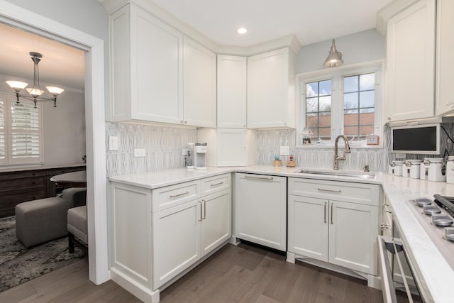 kitchen with sink, white cabinetry, hanging light fixtures, dark hardwood / wood-style floors, and backsplash