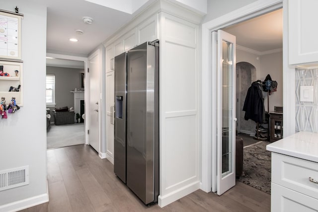 hall with crown molding and light hardwood / wood-style flooring