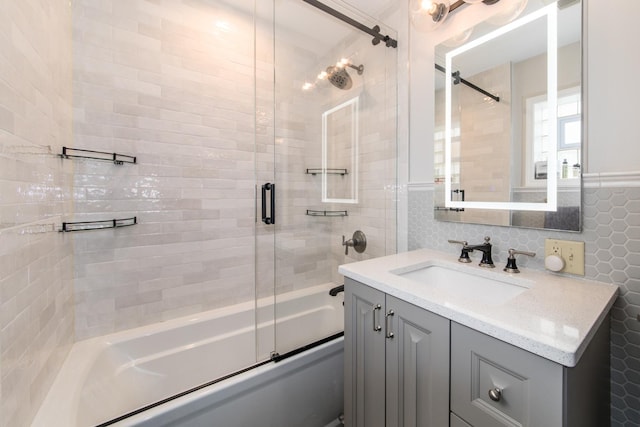 bathroom with decorative backsplash, vanity, combined bath / shower with glass door, and tile walls