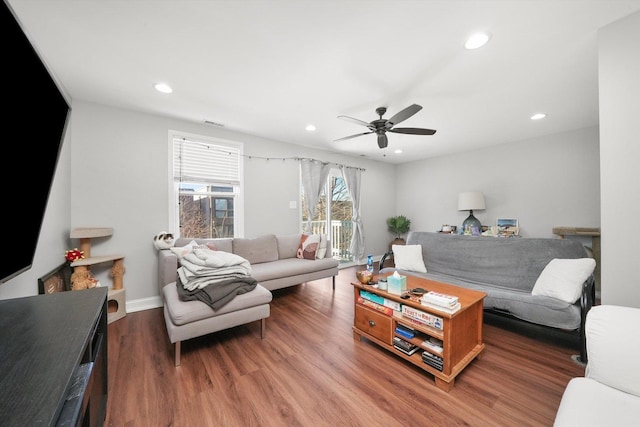 living room featuring ceiling fan and dark hardwood / wood-style flooring