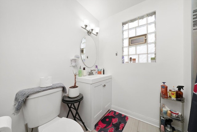 bathroom featuring lofted ceiling, vanity, toilet, and hardwood / wood-style floors