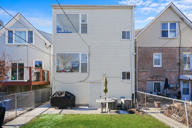 rear view of property featuring a yard, a patio area, and central air condition unit