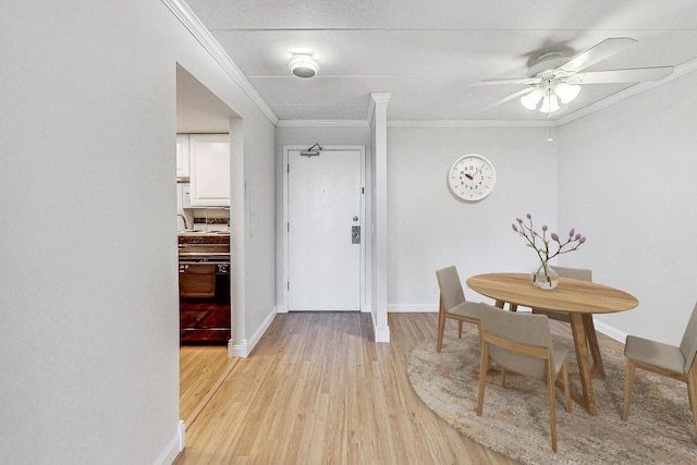 dining space featuring ceiling fan, light hardwood / wood-style floors, and crown molding