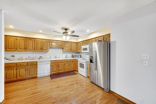 kitchen with sink, white appliances, light hardwood / wood-style flooring, and ceiling fan