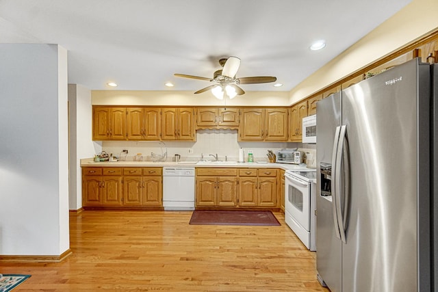 kitchen with sink, white appliances, ceiling fan, and light wood-type flooring