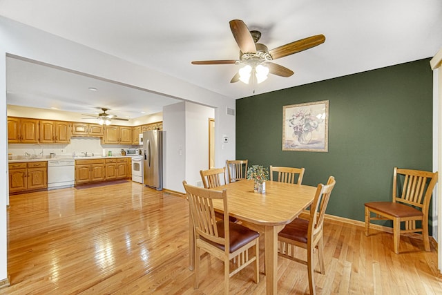 dining area featuring ceiling fan, sink, and light hardwood / wood-style floors