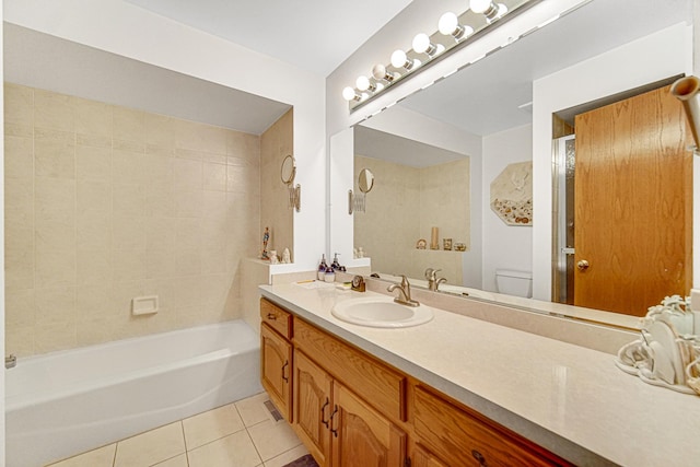 full bathroom featuring tile patterned flooring, vanity, tiled shower / bath, and toilet