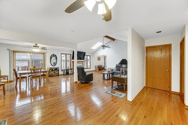 living room featuring vaulted ceiling with beams, ceiling fan, and light wood-type flooring