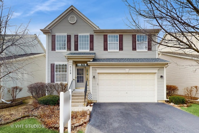 traditional-style home with driveway, roof with shingles, and an attached garage