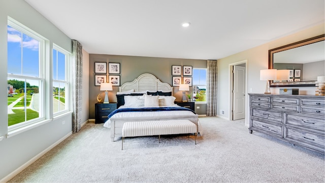 bedroom with light colored carpet and multiple windows