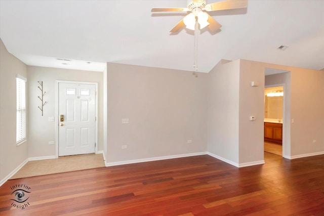 interior space with ceiling fan, vaulted ceiling, and wood-type flooring