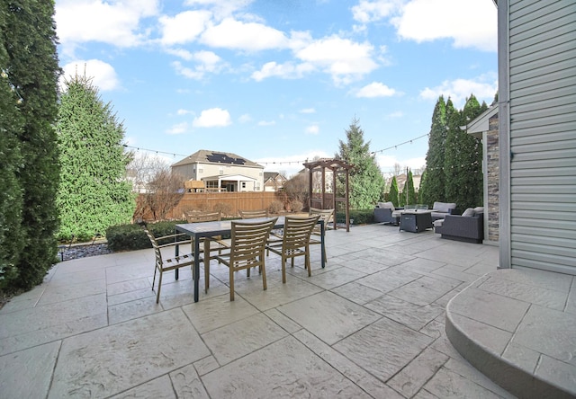 view of patio featuring outdoor dining space, fence, and an outdoor hangout area