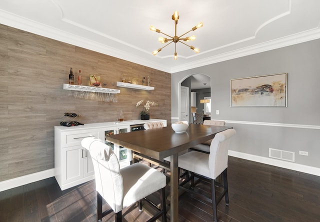 dining area with arched walkways, a notable chandelier, dark wood-type flooring, visible vents, and ornamental molding