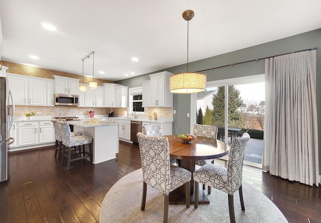 dining area with dark wood-style flooring and recessed lighting