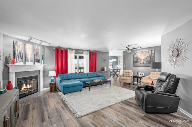 living room with wood-type flooring, track lighting, and ceiling fan