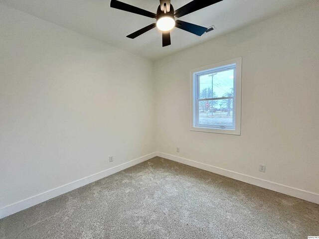 211 W Prairie St, Camp Point, IL 62320 - empty room featuring ceiling fan, dark carpet, and baseboards
