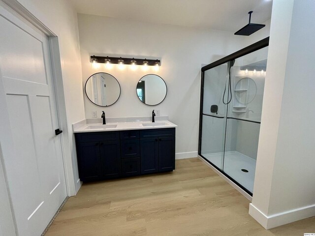 211 W Prairie St, Camp Point, IL 62320 - full bathroom featuring double vanity, a shower stall, wood finished floors, and a sink