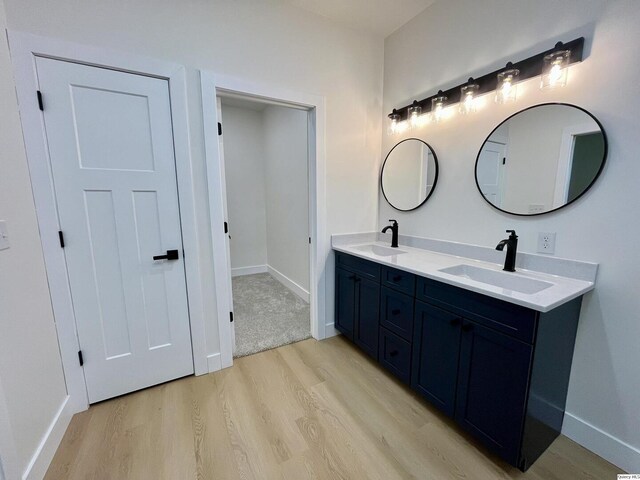 211 W Prairie St, Camp Point, IL 62320 - bathroom featuring double vanity, wood finished floors, baseboards, and a sink
