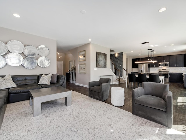 living room with dark wood-type flooring, recessed lighting, baseboards, and stairs