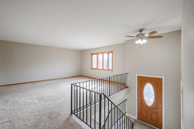 foyer with carpet floors and ceiling fan