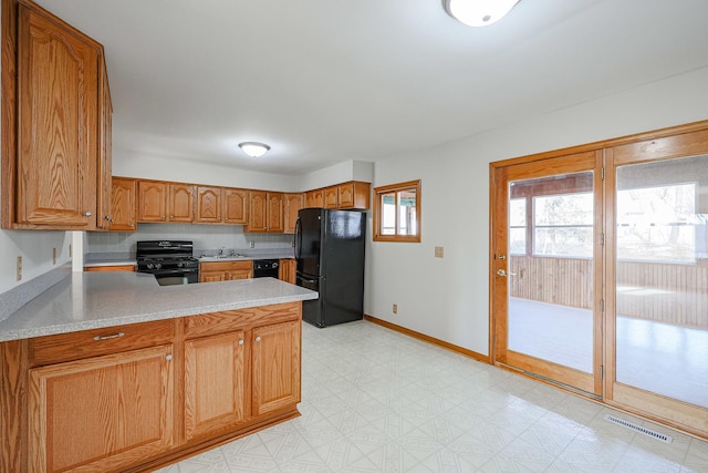 kitchen with sink, black appliances, and kitchen peninsula