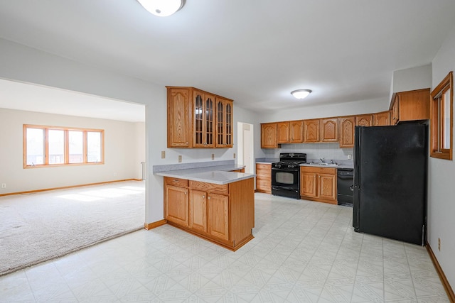 kitchen featuring tasteful backsplash, black appliances, sink, light colored carpet, and kitchen peninsula