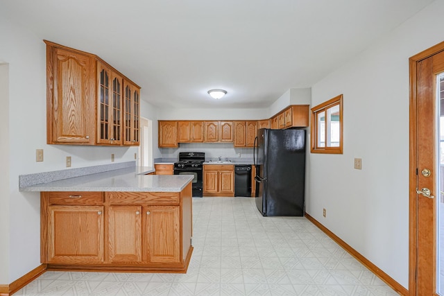 kitchen with kitchen peninsula, sink, and black appliances