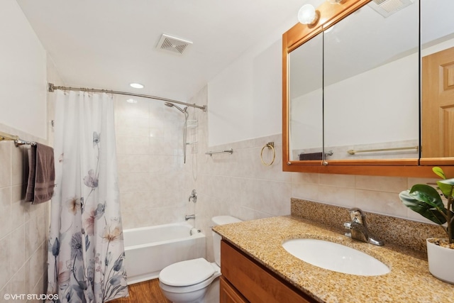 full bathroom featuring tile walls, vanity, toilet, and shower / bath combo with shower curtain