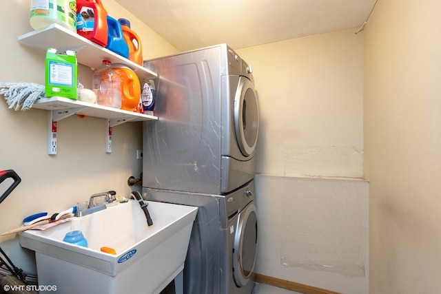 laundry room featuring sink and stacked washer / dryer