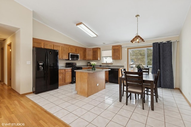 kitchen featuring a kitchen island, pendant lighting, lofted ceiling, black appliances, and light wood-type flooring