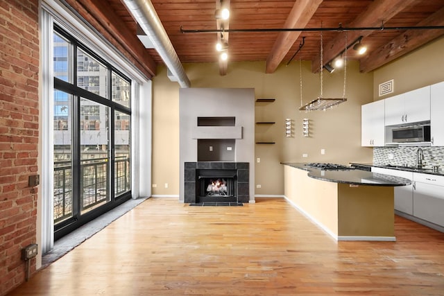 kitchen with appliances with stainless steel finishes, sink, white cabinets, decorative backsplash, and light wood-type flooring