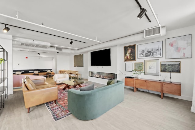 living room featuring track lighting and light hardwood / wood-style flooring