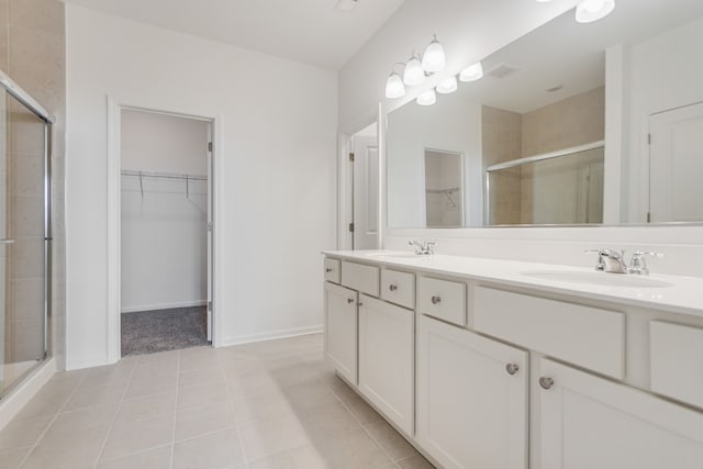 bathroom with tile patterned flooring, vanity, and walk in shower