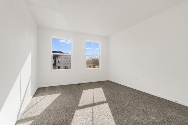 spare room featuring dark colored carpet