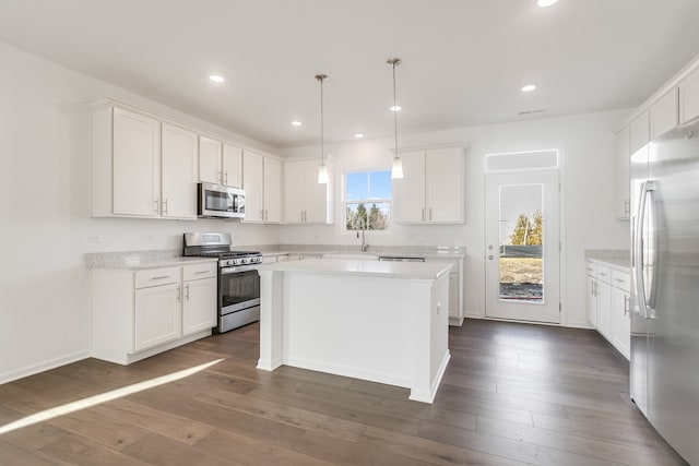 kitchen featuring stainless steel appliances, dark hardwood / wood-style flooring, a kitchen island, and white cabinets