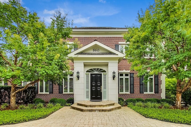 view of exterior entry with brick siding