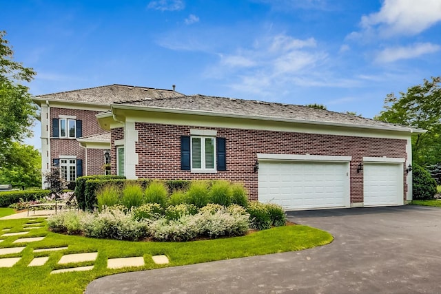 view of side of property featuring an attached garage, driveway, and brick siding