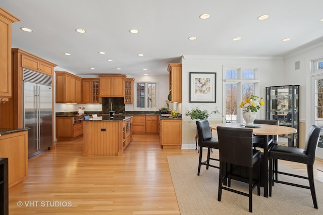 860 Gage Ln, Lake Forest, IL 60045 - kitchen featuring dark countertops, a kitchen island, glass insert cabinets, stainless steel built in refrigerator, and light wood-style floors