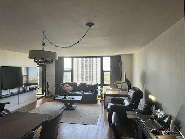 living room with an inviting chandelier, hardwood / wood-style flooring, and floor to ceiling windows