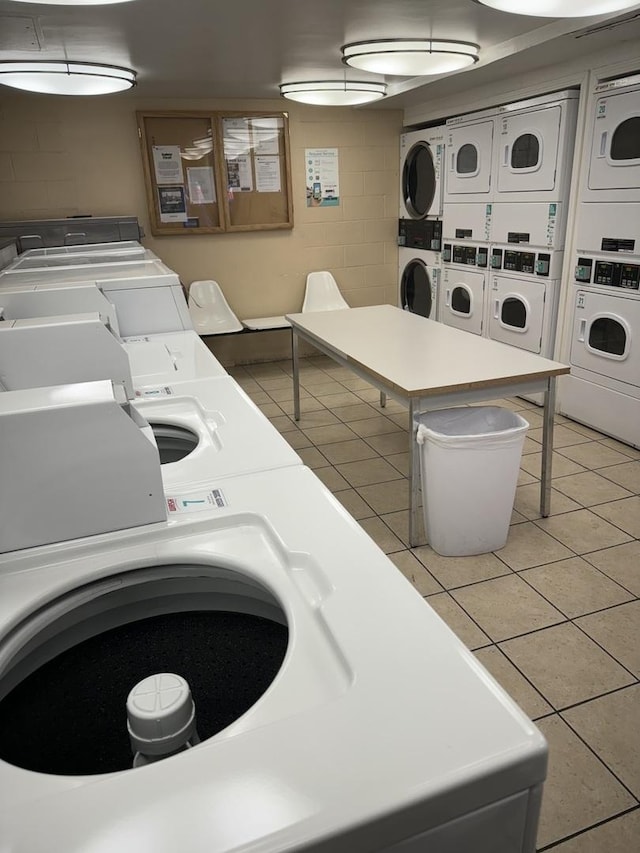 clothes washing area featuring separate washer and dryer, light tile patterned flooring, and stacked washing maching and dryer