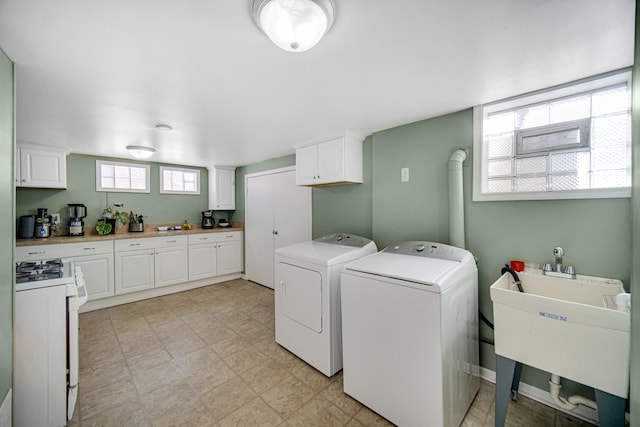 laundry area with separate washer and dryer and sink