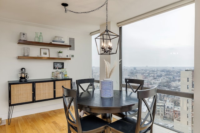 dining space with expansive windows, ornamental molding, hardwood / wood-style floors, and a chandelier