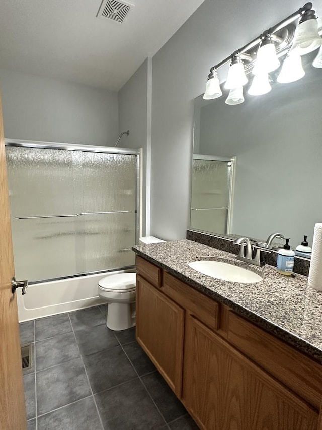 full bathroom featuring visible vents, bath / shower combo with glass door, toilet, tile patterned floors, and vanity