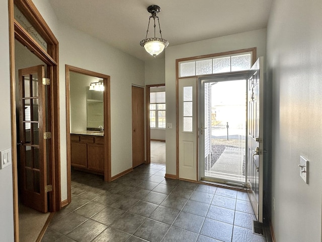 entrance foyer featuring dark tile patterned floors and baseboards