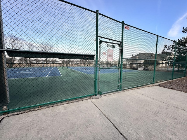 view of sport court featuring fence and a gate