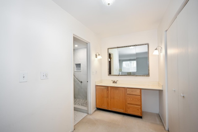 full bathroom with a tile shower and vanity